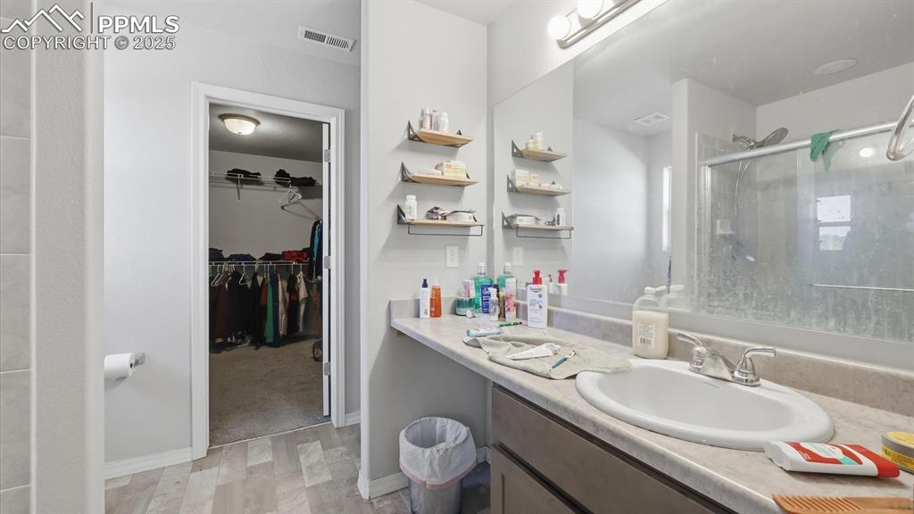 Image 18 of 36: The Primary Bathroom has an extended vanity, mirror, and enclosed shower.