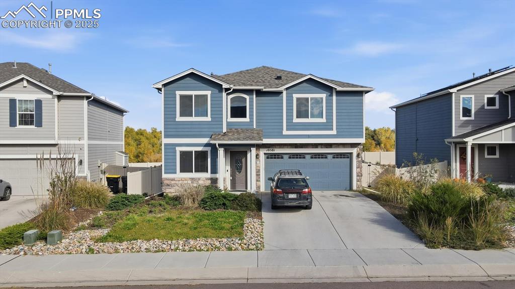 Image 7 of 36: Front view of home with concrete driveway and 2-car attached garage.