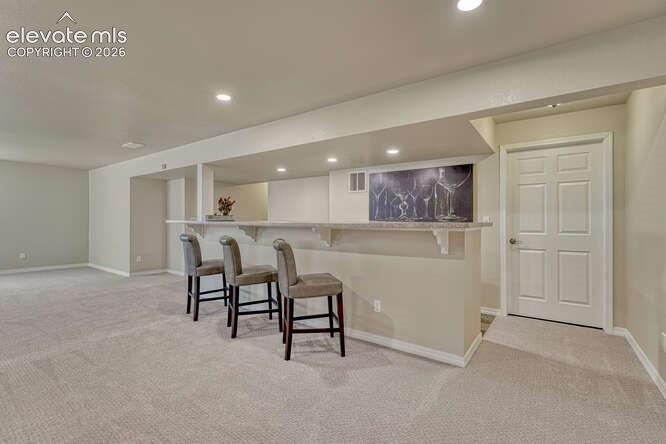 Image 23 of 42: Basement bar area leading into the utility/storage space
