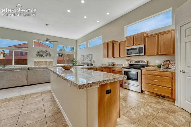 Image 34 of 42: Open concept kitchen/dining area with tile flooring & walk in pantry