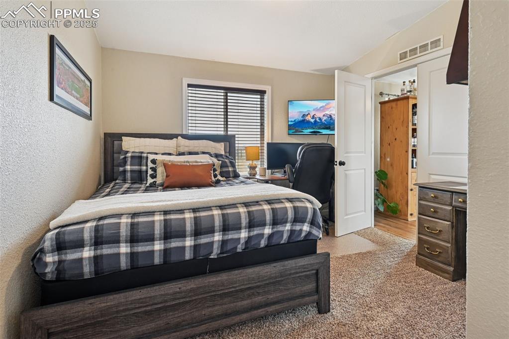 Image 15 of 31: Bedroom with a textured wall and light colored carpet
