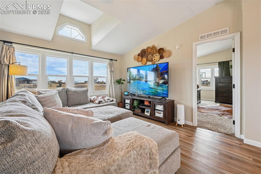 Image 3 of 31: Living room with lofted ceiling and wood finished floors