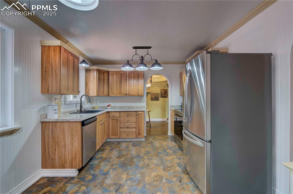Image 11 of 50: Kitchen featuring appliances with stainless steel finishes, light counterto