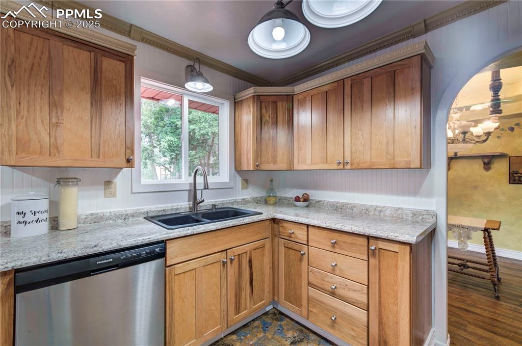 Image 13 of 50: Kitchen with stainless steel dishwasher, ornamental molding, brown cabinetr