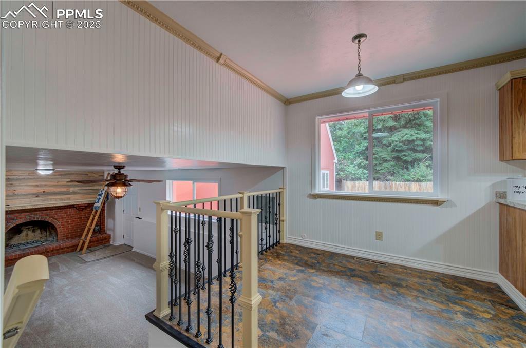 Image 16 of 50: Corridor with crown molding, an upstairs landing, and wood walls