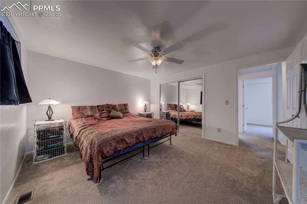 Image 17 of 50: Bedroom featuring light colored carpet, a ceiling fan, and a closet