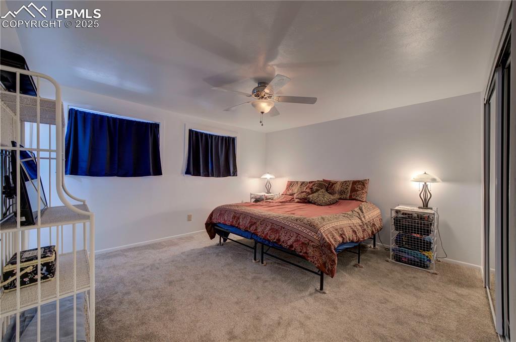 Image 18 of 50: Carpeted bedroom with a closet and a ceiling fan
