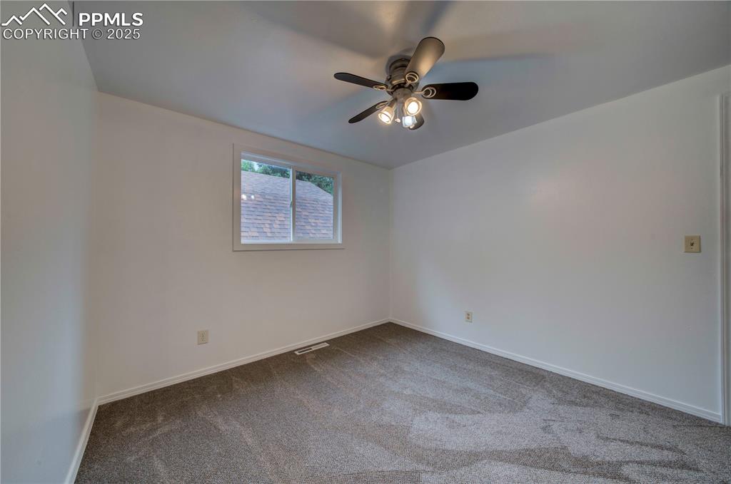 Image 21 of 50: Carpeted empty room with baseboards and ceiling fan