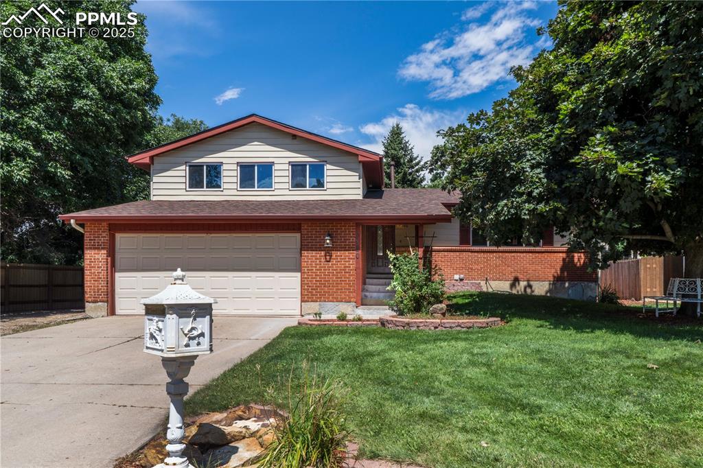 Image 3 of 50: View of front facade featuring an attached garage, concrete driveway, a shi