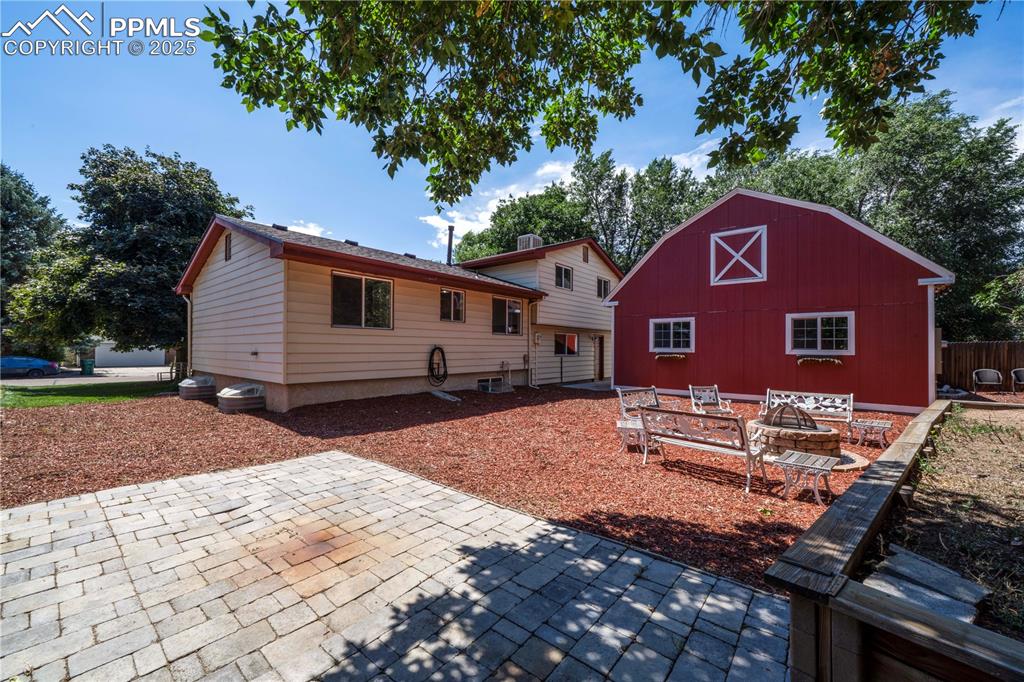 Image 4 of 50: Back of property with a patio area and an outdoor structure