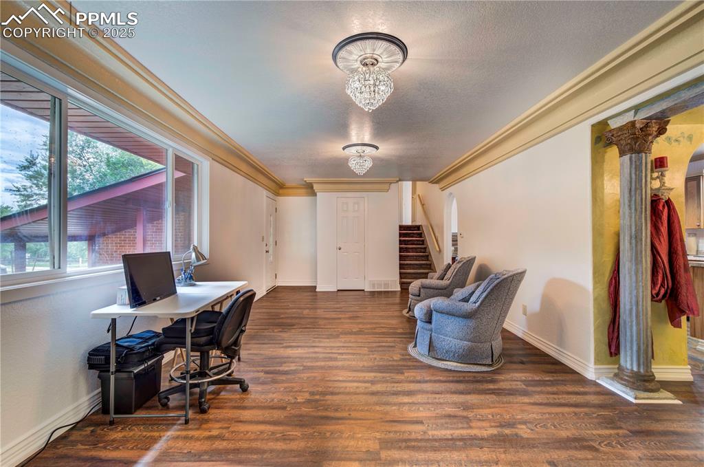 Image 7 of 50: Office area with dark wood-type flooring, crown molding, a textured ceiling