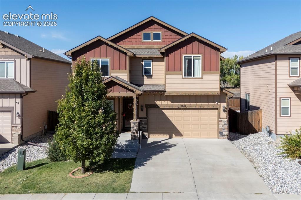 Caption: Two-story residence featuring a two-car garage, stone accents, and a covered front entry