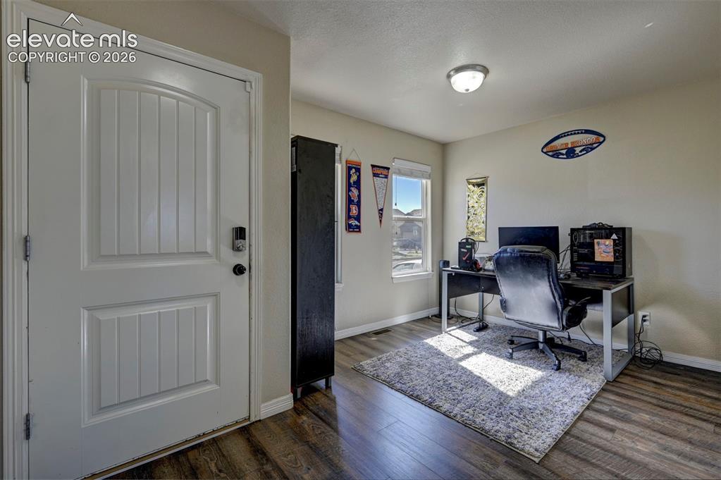 Image 10 of 45: White paneled entry door with smart lock, wood-finish flooring, and two win