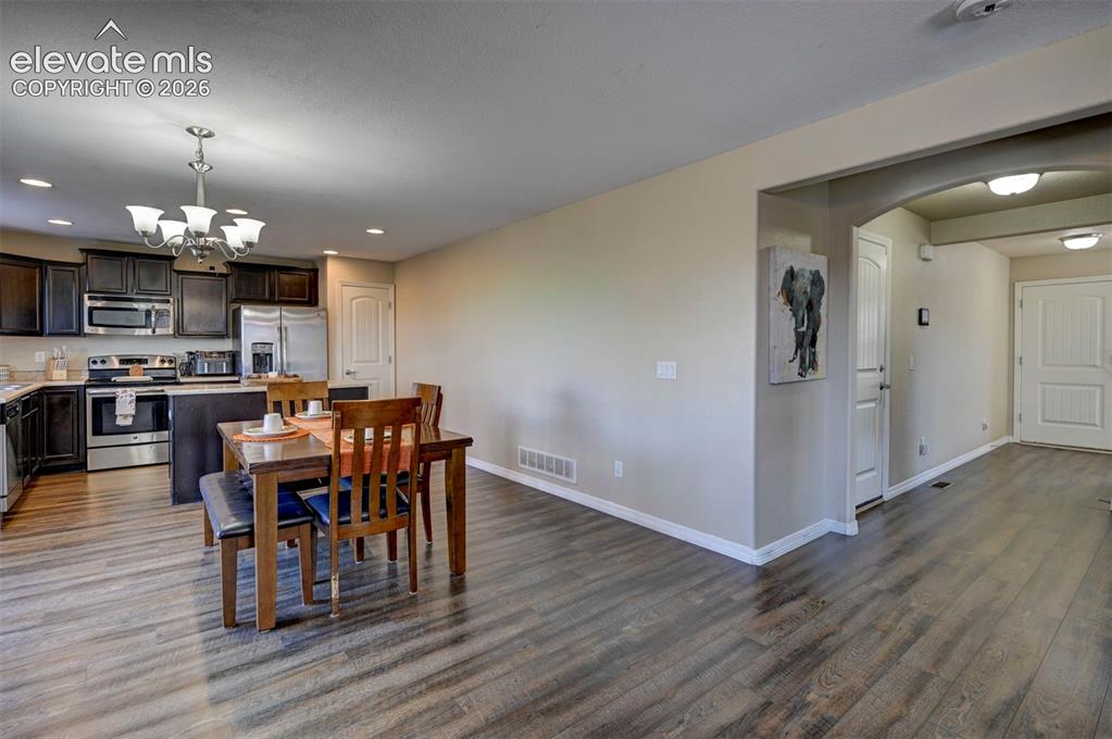 Image 15 of 45: Wood-finish flooring throughout, kitchen with dark wood cabinetry, stainles