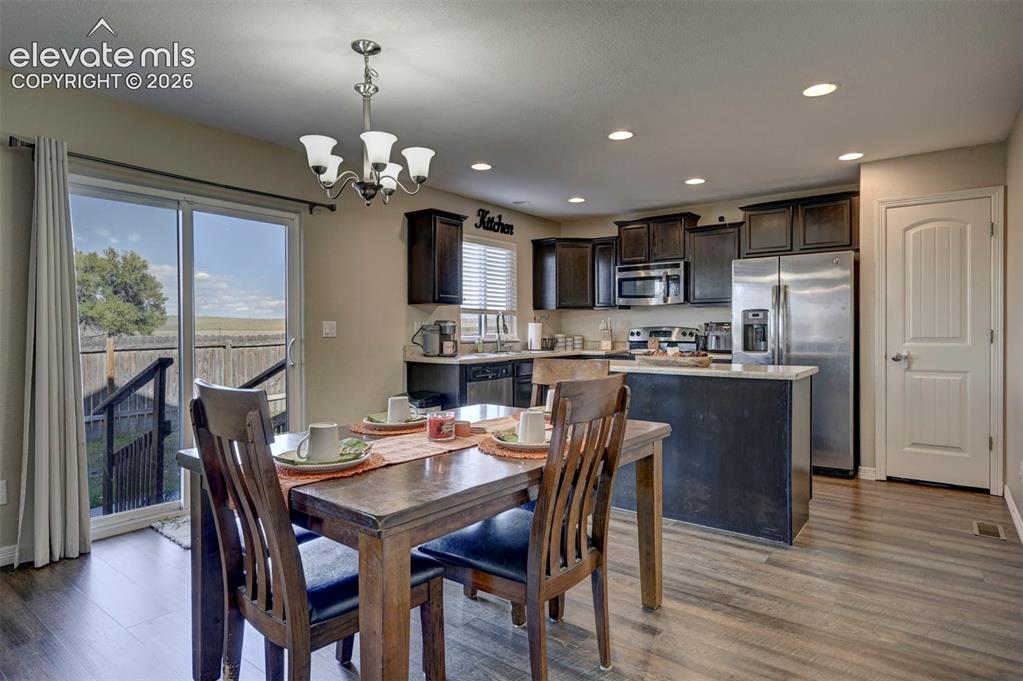 Image 17 of 45: Kitchen area featuring dark wood cabinetry, stainless steel appliances, a c