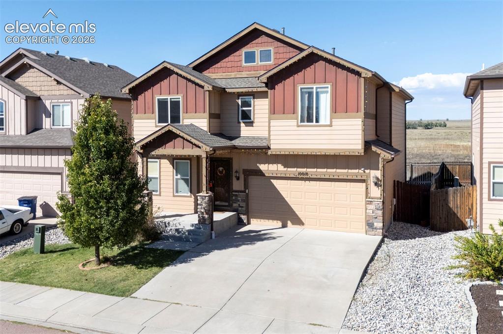 Image 2 of 45: Two-story residence with a two-car garage, concrete driveway, and stone col