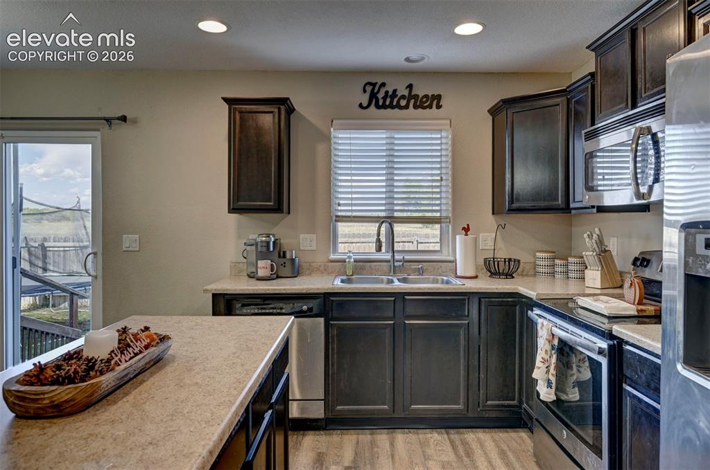 Image 20 of 45: Kitchen featuring dark wood-finish cabinetry, stainless steel appliances, a