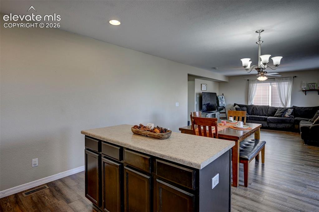 Image 21 of 45: Kitchen island with ample cabinetry, light-toned countertop, and recessed l