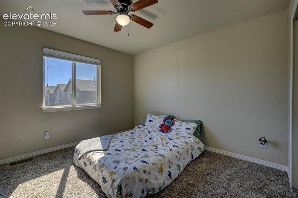 Image 25 of 45: Carpeted room featuring a window with white trim, a ceiling fan with integr