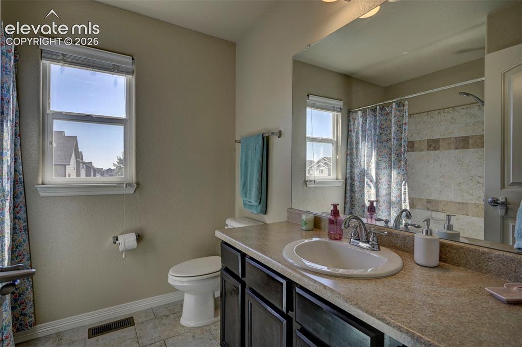 Image 27 of 45: Window with blinds, vanity with integrated sink, chrome faucet, wall-mounte
