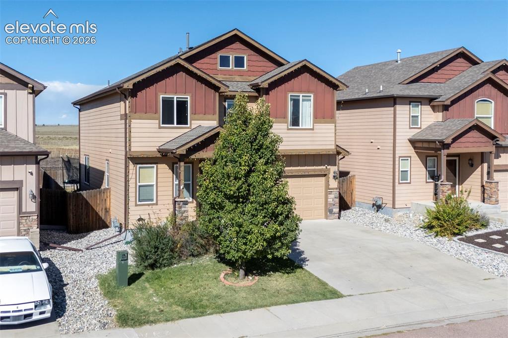 Image 3 of 45: Two-story residence featuring a two-car garage, concrete driveway, and a co