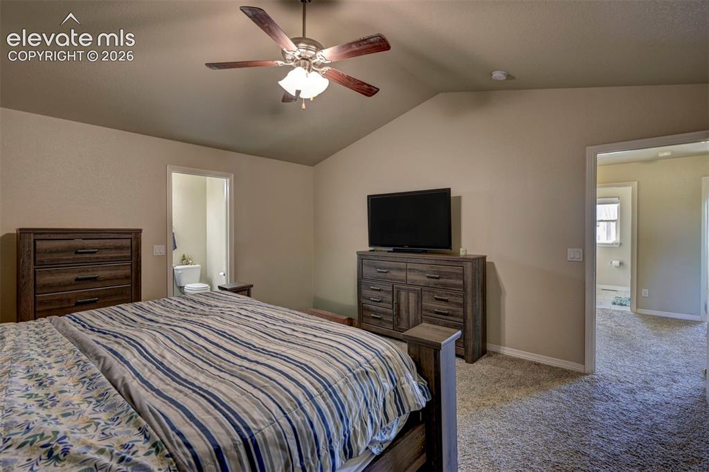 Image 32 of 45: Vaulted ceiling with a ceiling fan, neutral wall color, and carpet flooring