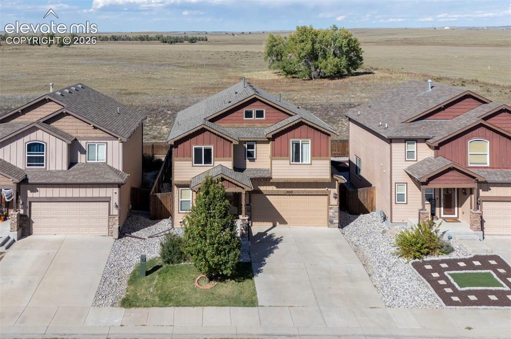 Image 4 of 45: Two-story exterior with a covered entry, attached garage, and stone accents