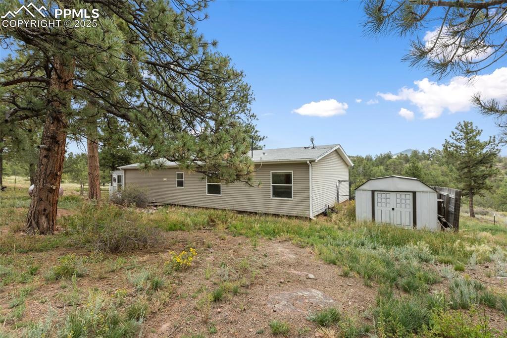 Image 5 of 37: Rear view of house with a storage shed