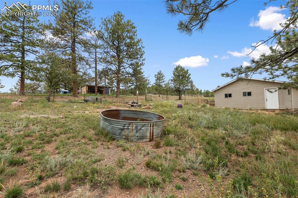 Image 8 of 37: View of detached garage and rear yard with a view of pasture area fully fe