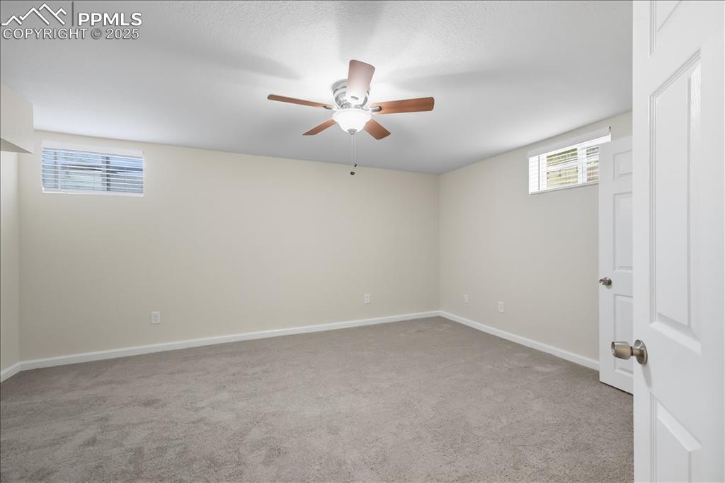 Image 15 of 22: Unfurnished bedroom featuring light colored carpet, a ceiling fan, and a te