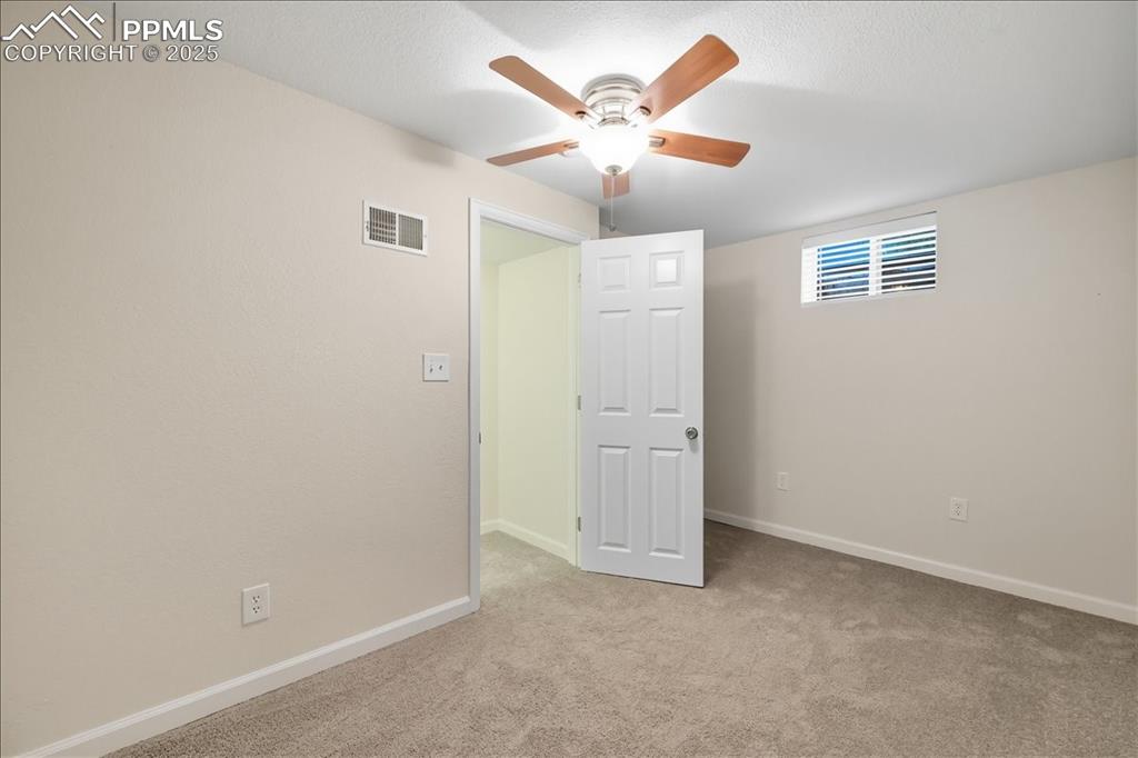 Image 16 of 22: Unfurnished bedroom featuring light carpet and ceiling fan