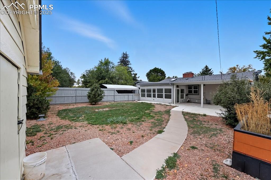 Image 18 of 22: Fenced backyard with a patio area and a sunroom