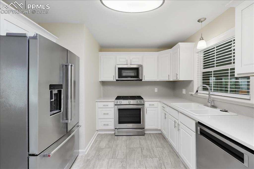 Image 9 of 22: Kitchen with appliances with stainless steel finishes, white cabinetry, and