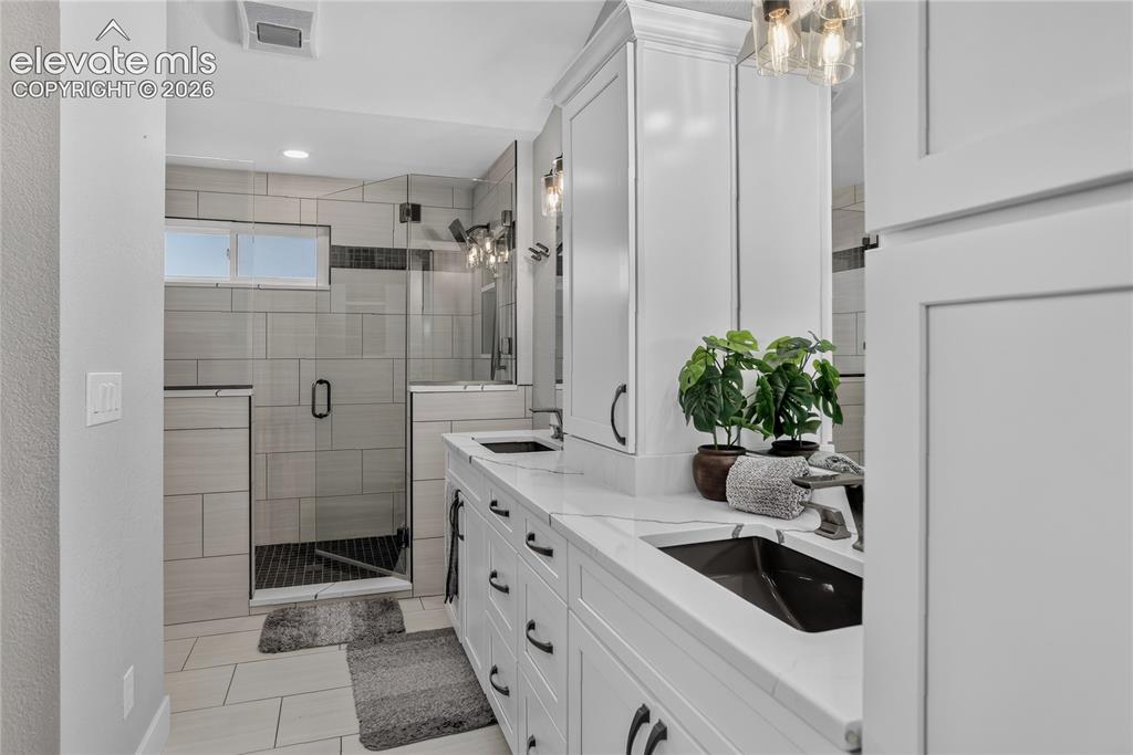 Image 17 of 29: Primary bath w/ dual sink vanity & heated floors