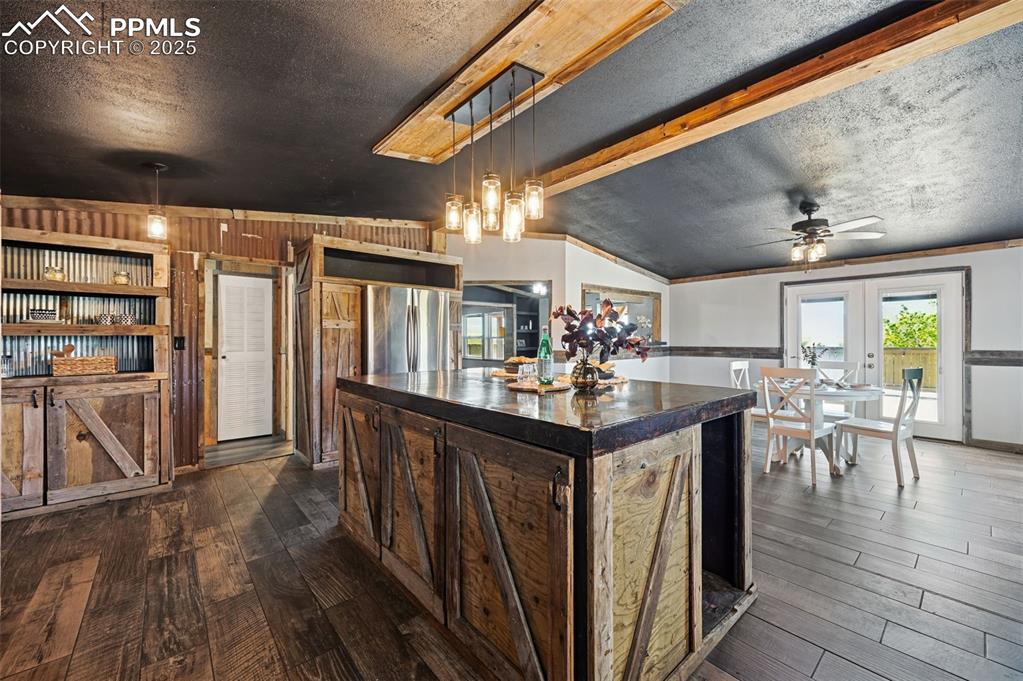 Image 9 of 50: Open concept kitchen dining with french doors to deck