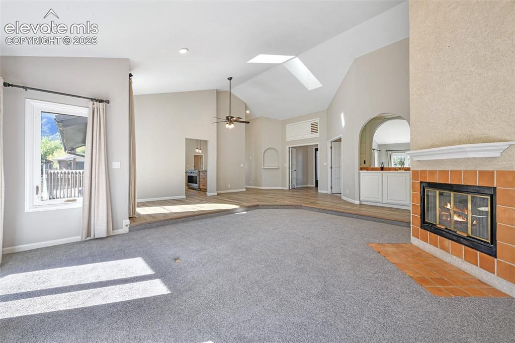 Image 11 of 46: Vaulted ceilings with skylights, sunken carpeted floor, fireplace with maso