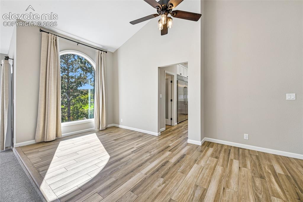 Image 13 of 46: Vaulted ceilings featuring a central wood-finish ceiling fan, wood-finish f