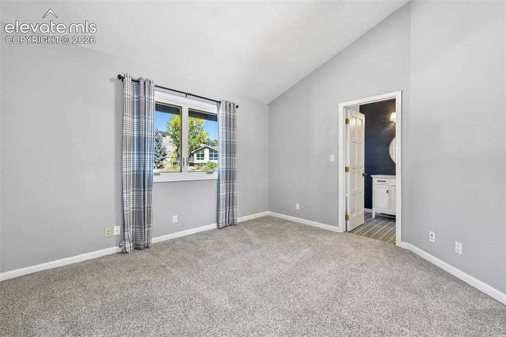 Image 14 of 46: Room featuring neutral wall tones, vaulted ceilings, and wall-to-wall carpe