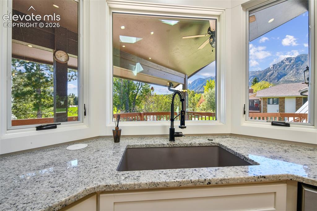 Image 23 of 46: Bay window featuring expansive stone countertops, a large rectangular under