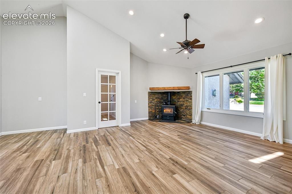 Image 24 of 46: Vaulted ceilings, wood-finish flooring, stone-surround wood-burning stove w