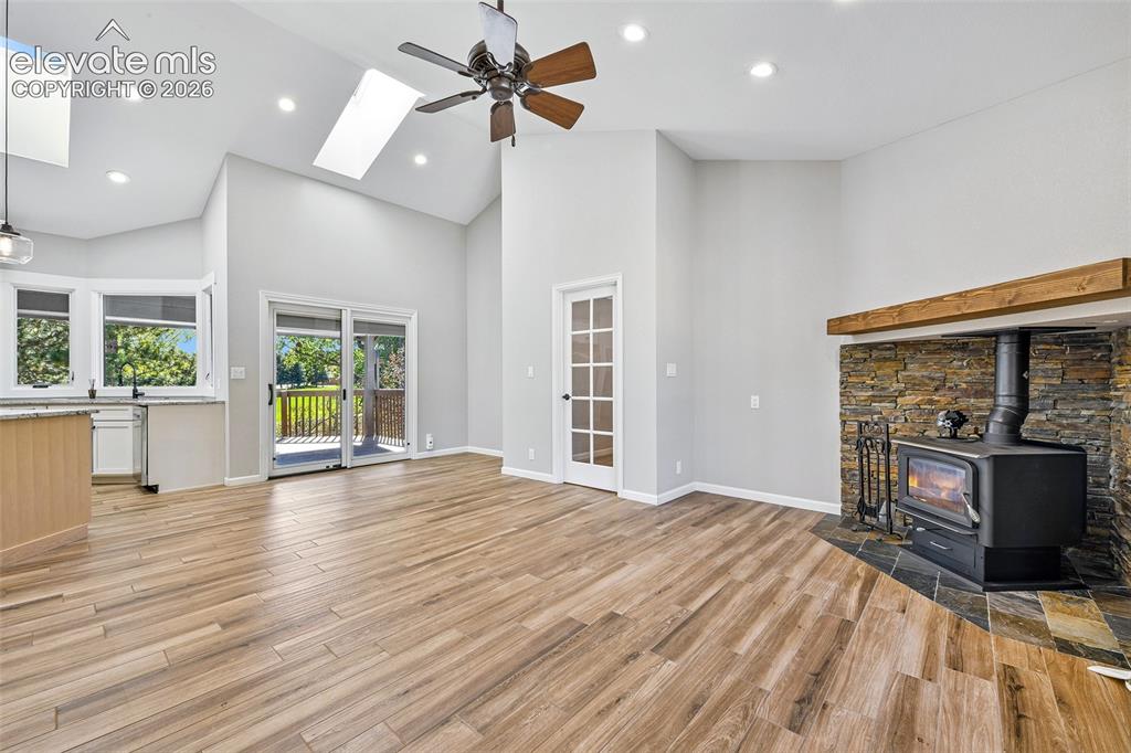 Image 25 of 46: Vaulted ceilings with skylights, wood-finish flooring, stone-accented firep