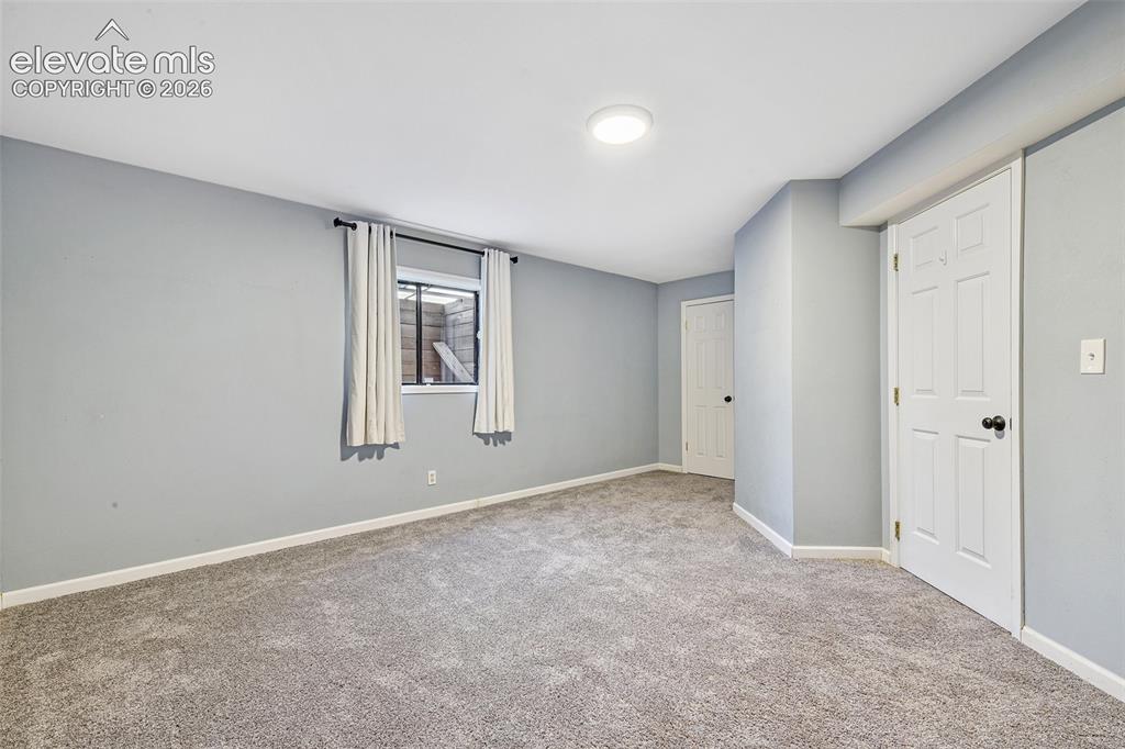 Image 31 of 46: Neutral-toned wall paint, neutral carpeting, and two six-panel interior doo
