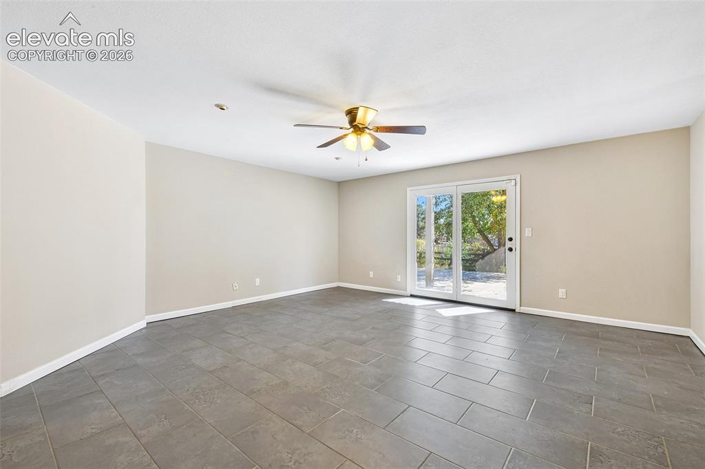 Image 32 of 46: Neutral-toned interior featuring large-format tile flooring, a ceiling fan