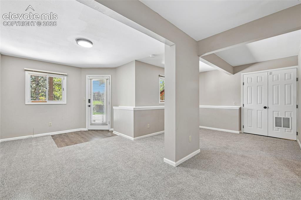 Image 36 of 46: Neutral wall-to-wall carpeting, wood-finish flooring at the entrance, white