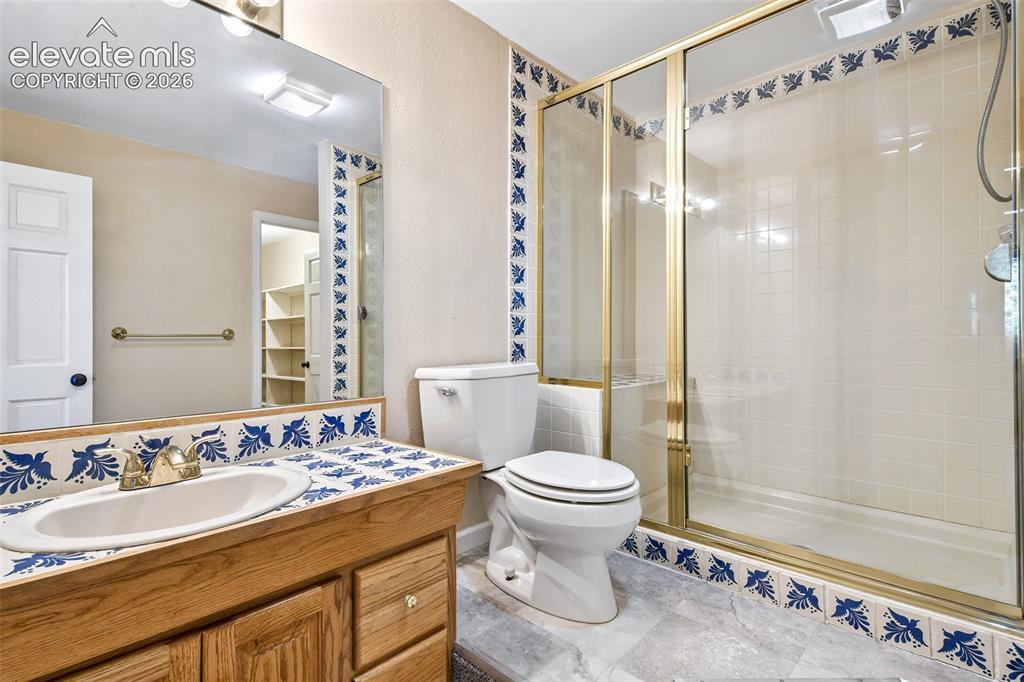 Image 37 of 46: Bathroom featuring a wood-finish vanity with an integrated basin, decorativ