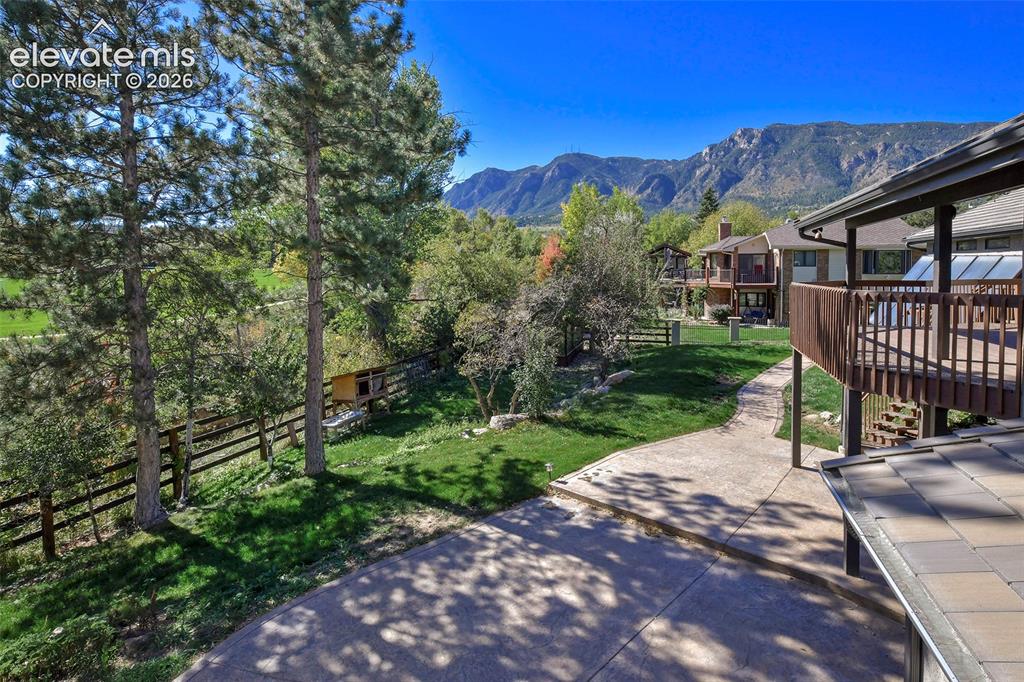 Image 4 of 46: Backyard space featuring a concrete patio, elevated wooden deck, wood-rail 