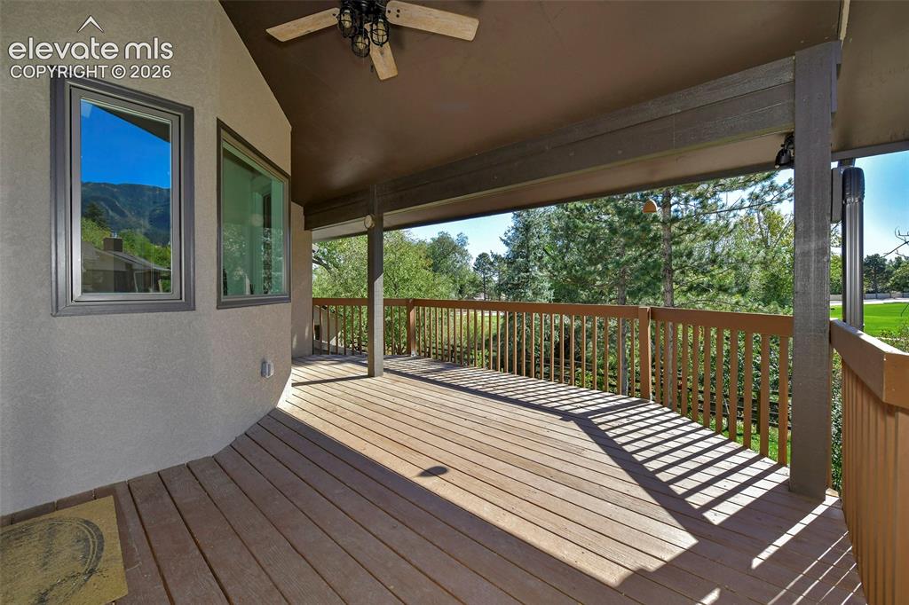Image 7 of 46: Covered deck featuring wood-finish flooring, a ceiling fan, and wooden rail