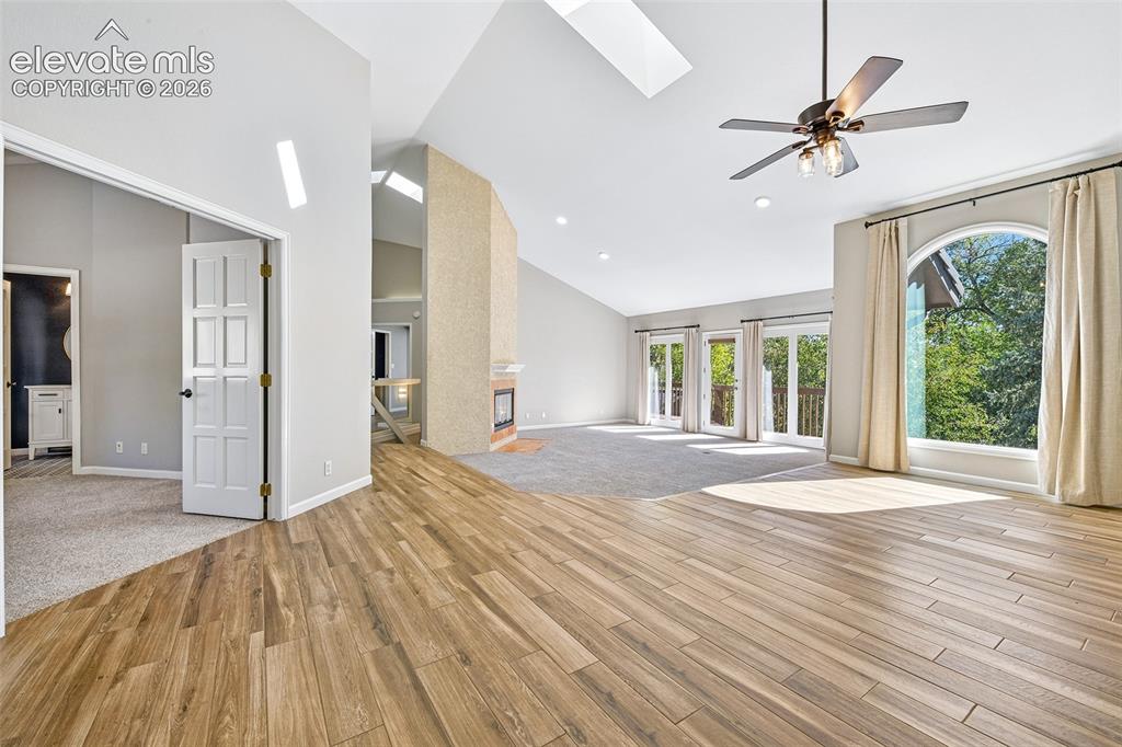 Image 8 of 46: Vaulted ceilings with integrated skylights, wood-finish flooring, floor-to-