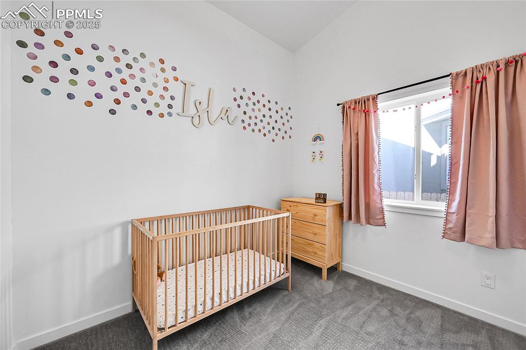 Image 17 of 29: Bedroom with carpet flooring and a nursery area
