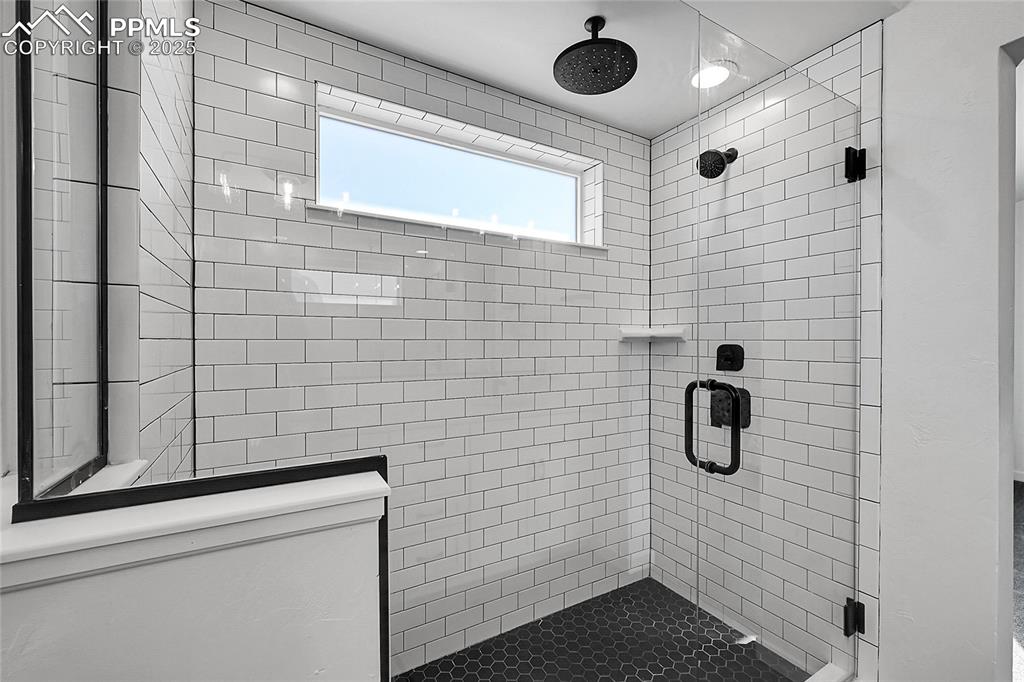 Image 21 of 29: Bathroom featuring a stall shower